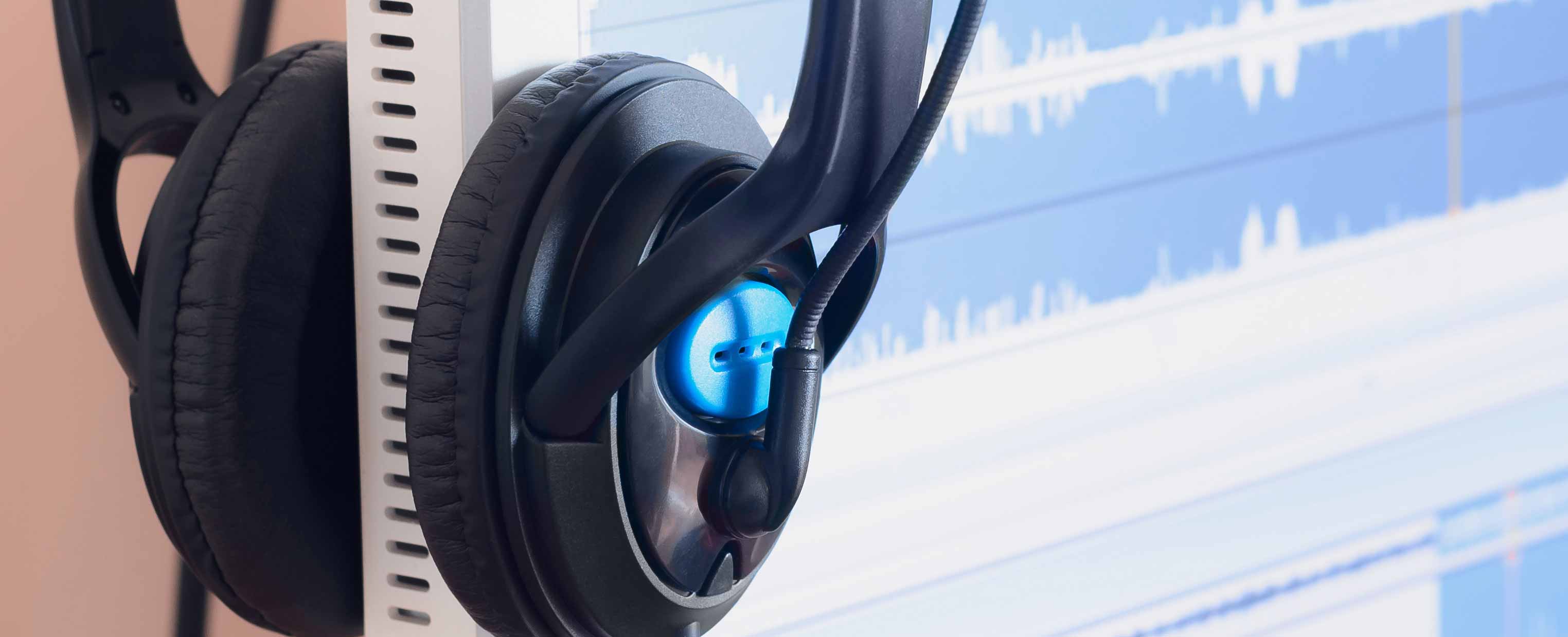 big black headphones lie on the wooden desktop