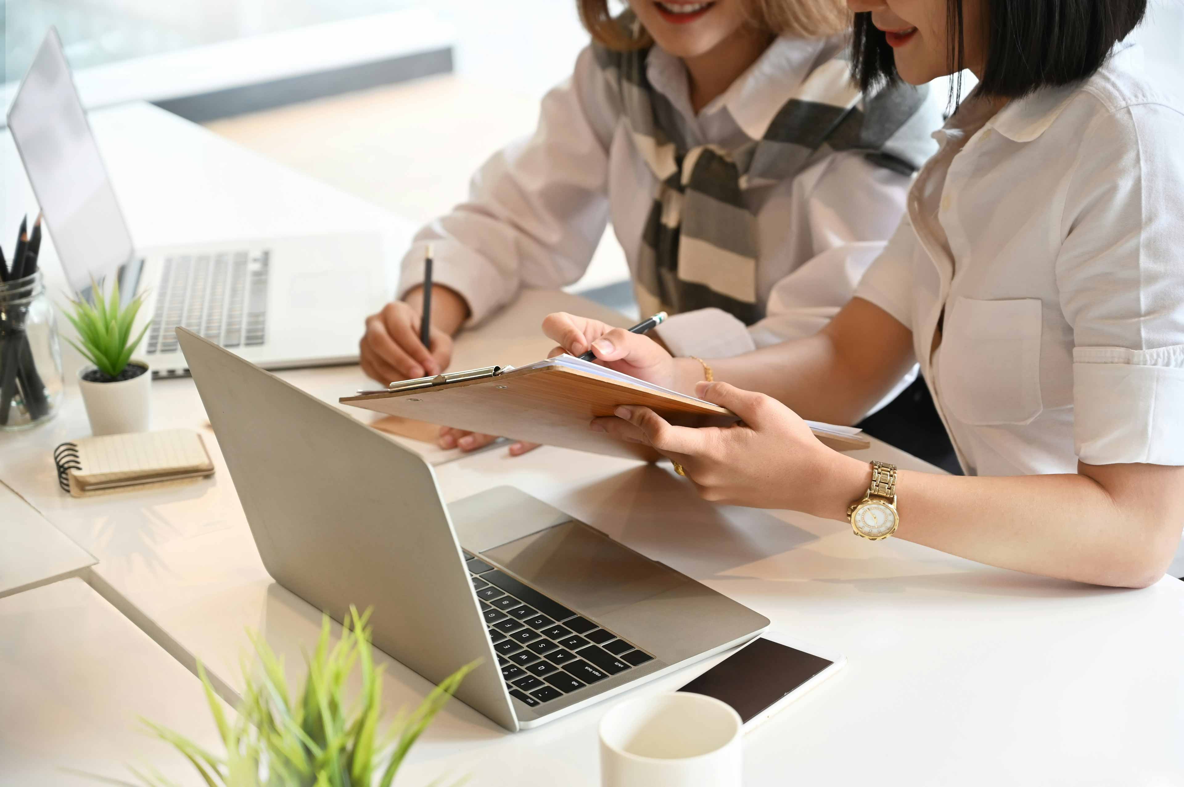 female worker doing on work on two computers at the same time